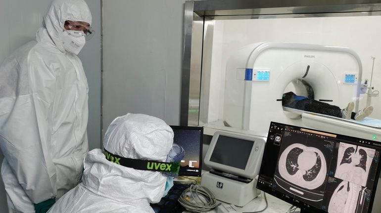 Doctors scan a patient's lungs at Huoshenshan temporary hospital built...