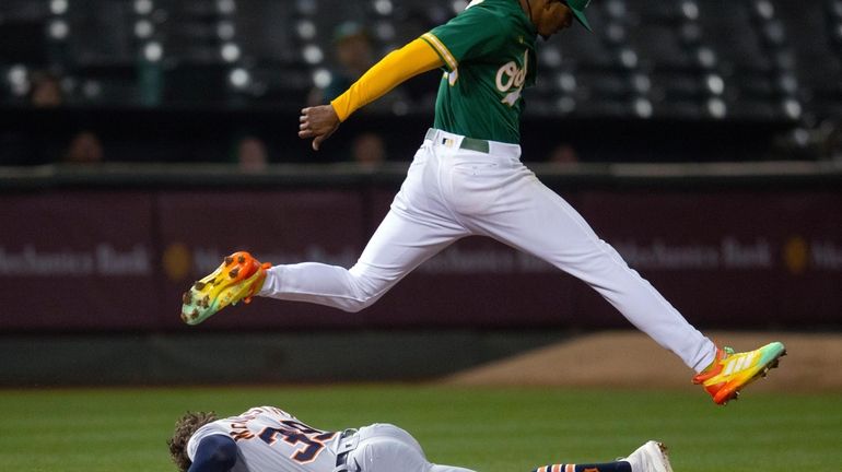 Oakland Athletics starting pitcher Luis Medina jumps over Detroit Tigers'...