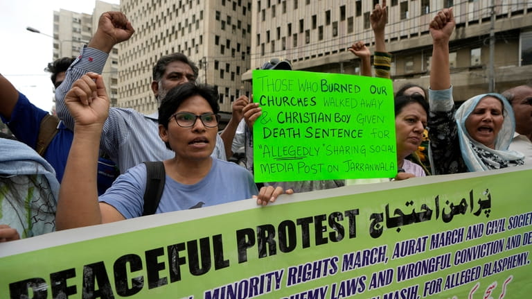 Members from Pakistan's minority community and civil society chant slogans...