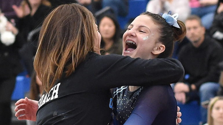 Hannah Hughes of Middle Country gets congratulated by her coach,...