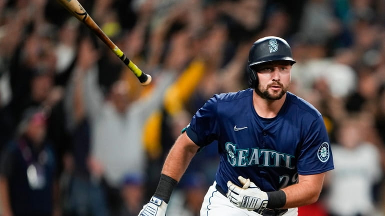 Seattle Mariners' Cal Raleigh flips his bat after hitting a...