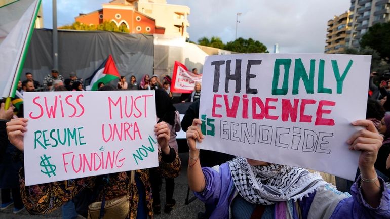 Activists hold placards during a protest demanding countries to resume...