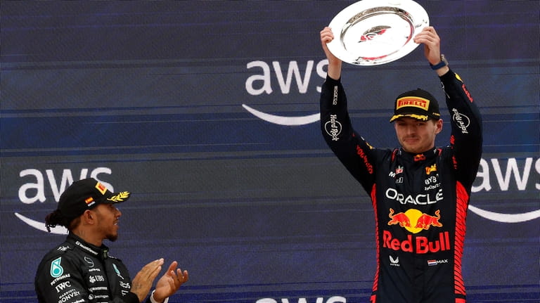 Mercedes driver Lewis Hamilton of Britain, left, applauds to winner...