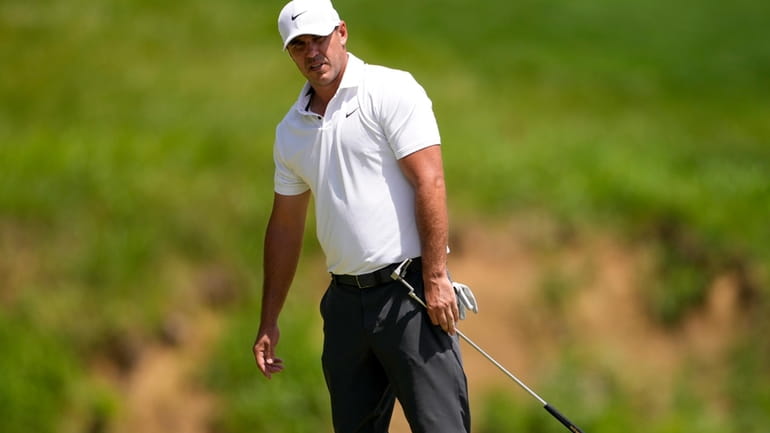 Brooks Koepka reacts after missing a putt on the third...