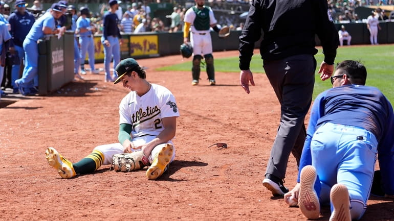 Oakland Athletics first baseman Tyler Soderstrom, left, reacts after colliding...