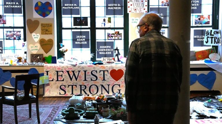 Volunteer Rich Beard looks over archived items, many left at...