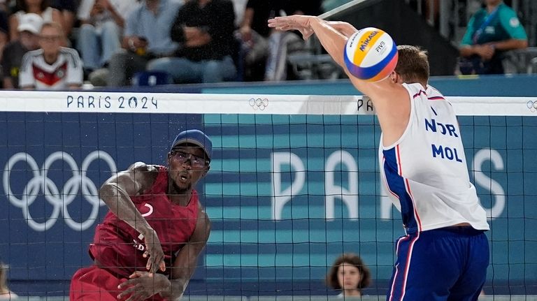 Qatar's Ahmed Tijan, left, scores a point against Norway during...