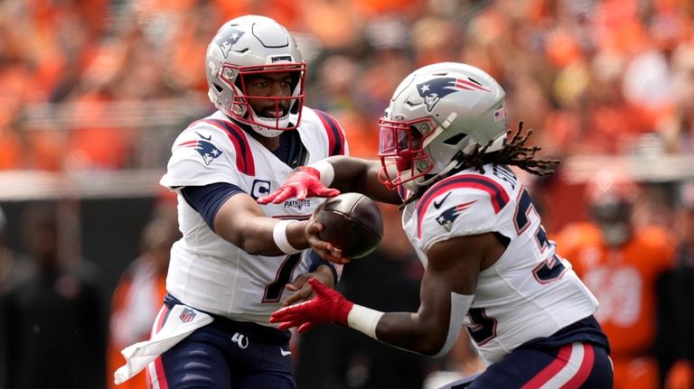 New England Patriots quarterback Jacoby Brissett (7) hands the ball...