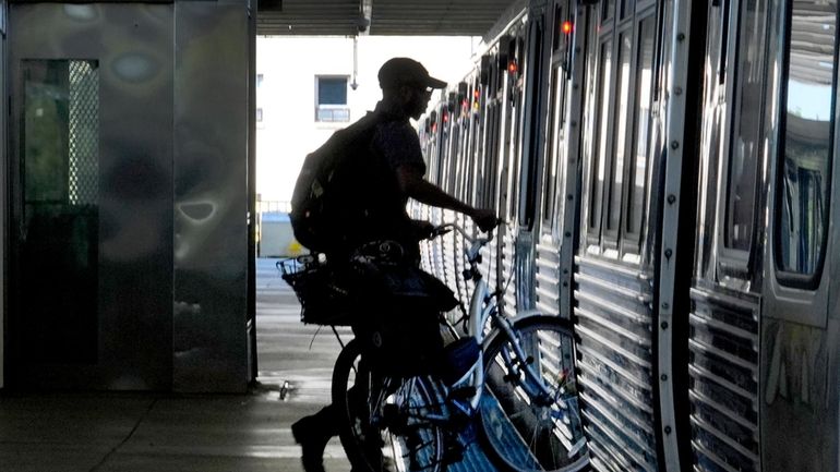 A cyclist enters a Chicago Transit Authority Blue Line train...