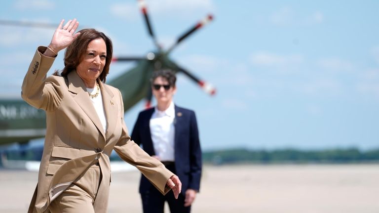 Vice President Kamala Harris, left, waves as she arrives to...