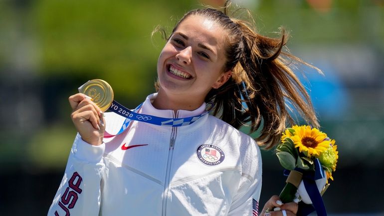 Nevin Harrison, of the United States, holds her up gold...