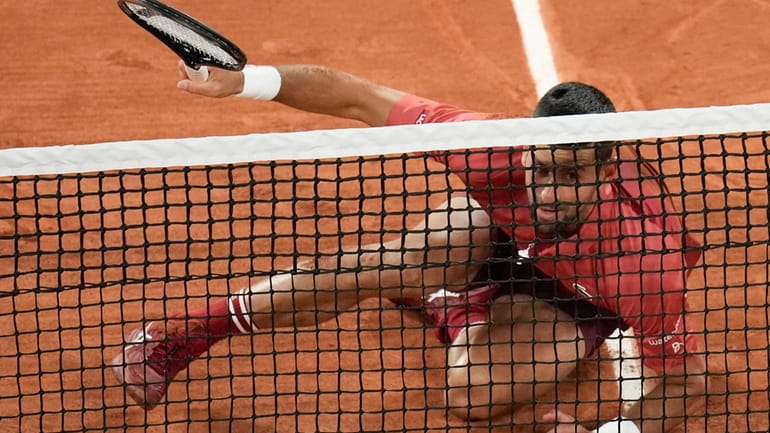 Serbia's Novak Djokovic slips when playing a shot close to...