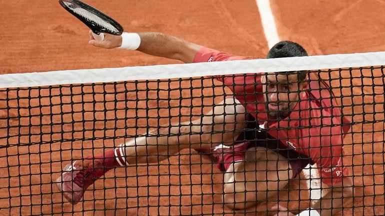 Serbia's Novak Djokovic slips when playing a shot close to...