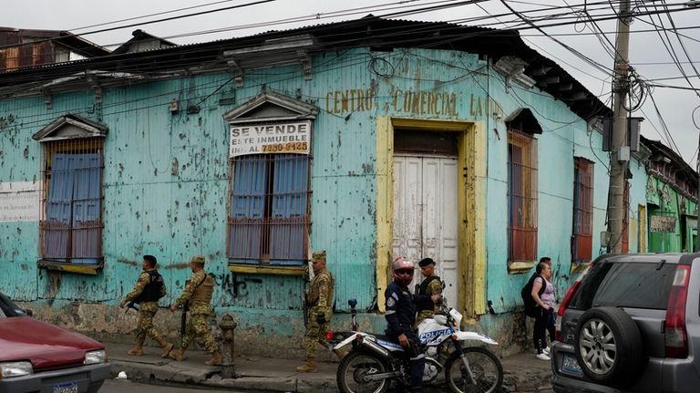 Soldiers on patrol walk past, a day ahead of the...