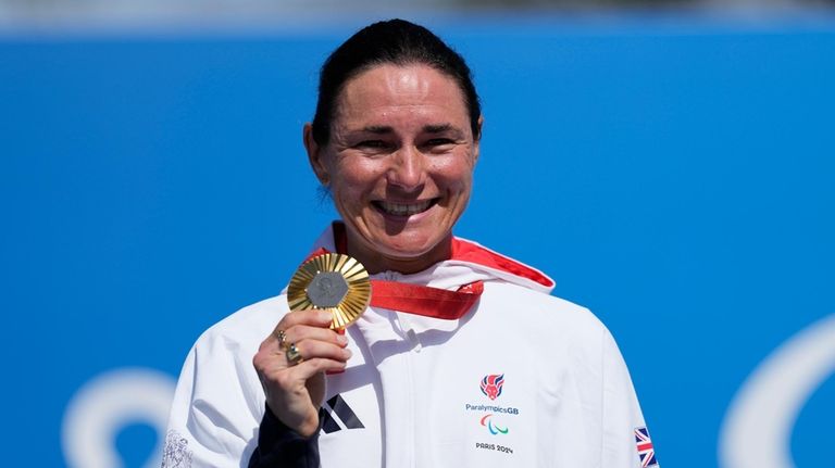 Britain's Sarah Storey celebrates with her gold medal after winning...