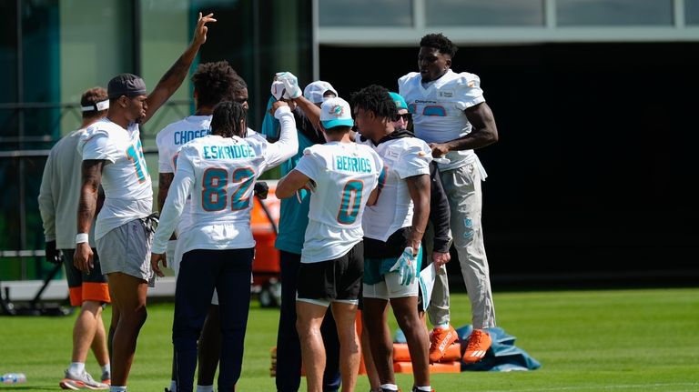 Miami Dolphins wide receiver Tyreek Hill, right, jumps up as...