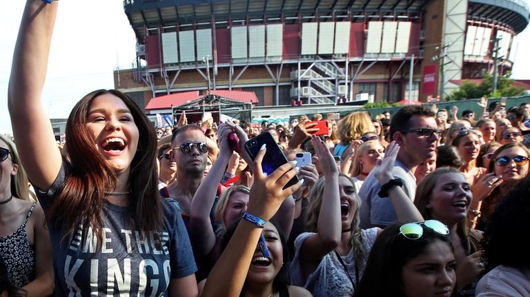 The crowd cheers We The Kings on stage for the...