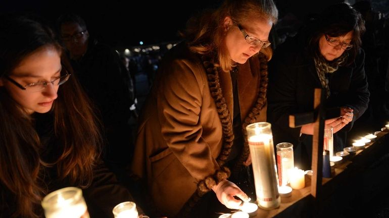 People gather for a prayer vigil at St. Rose Church...