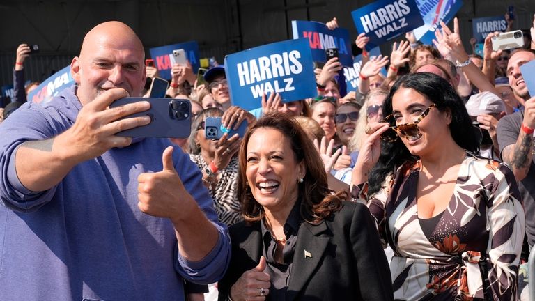 Democratic presidential nominee Vice President Kamala Harris takes a selfie...