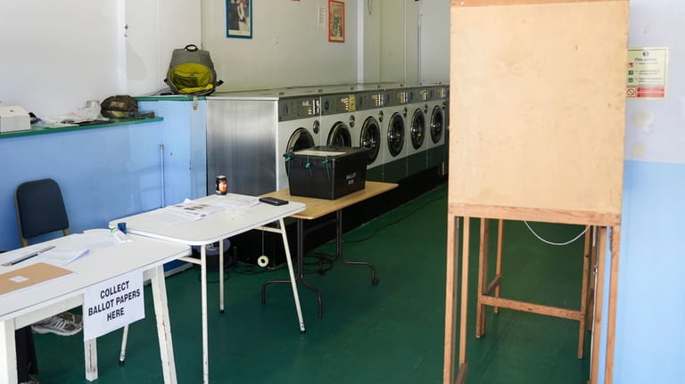 A polling station is installed inside a launderette for the...