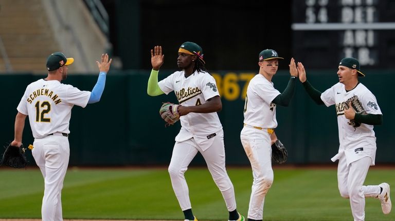 Oakland Athletics right fielder Lawrence Butler, second from left, celebrates...