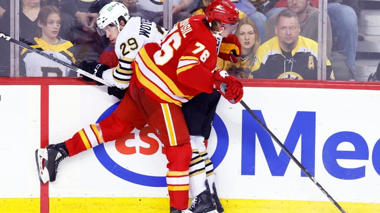 Boston Bruins' Parker Wotherspoon, left, is hit by Calgary Flames'...