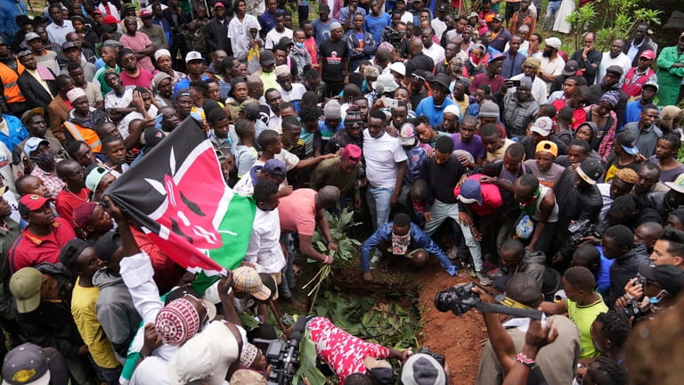 Relatives and friends bury the body of 19-year-old Ibrahim Kamau,...