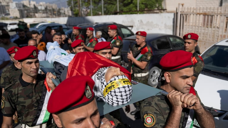 A Palestinian honor guard carries the body of Labeeb Dumaidi,...