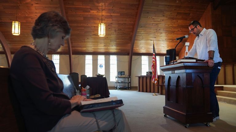 Gail Farnham, left, listens as Pastor Ryan Burge preaches a...