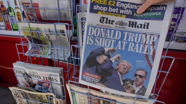 A woman buys a copy of the British Mail on...