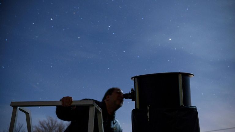 Andrew Herzman, of Farmingdale, peers at a distant galaxy through...