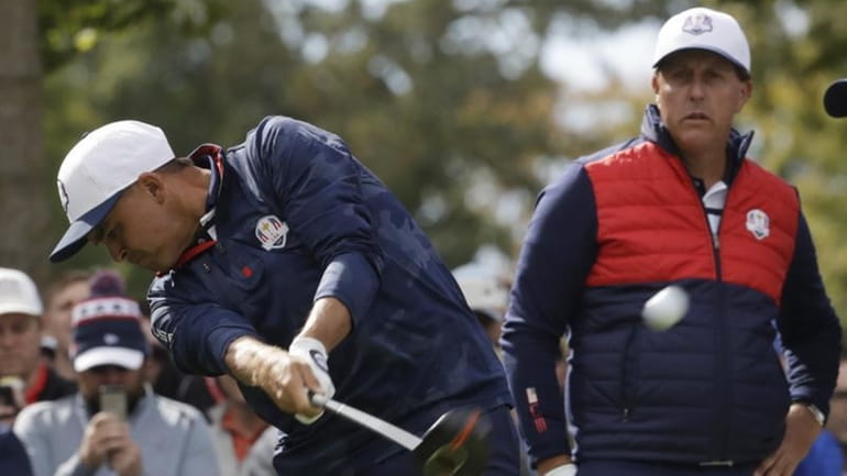 United States' Phil Mickelson watches as United States' Rickie Fowler...