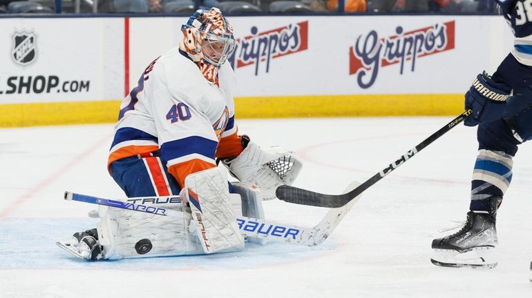 Islanders' Semyon Varlamov, left, makes a save against Columbus Blue...