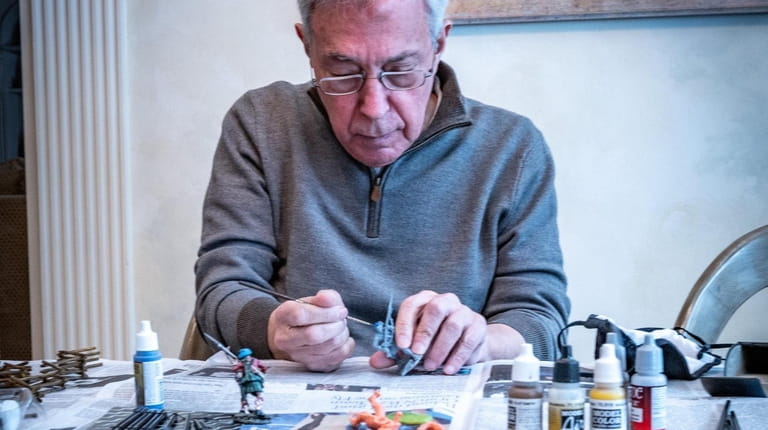 Syosset resident Richard Schuster hand-paints his miniature soldiers, which are...
