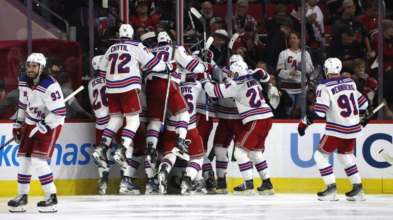 The Rangers celebrate after their game-winning goal against the Carolina...