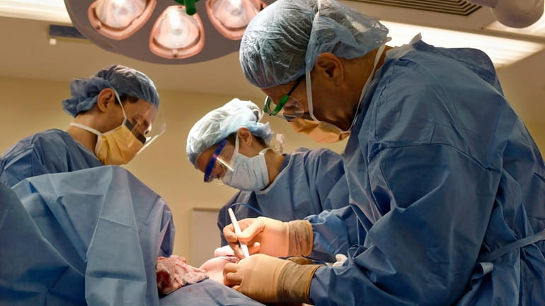 Surgeons perform a bilateral mastectomy on a transgender patient at...