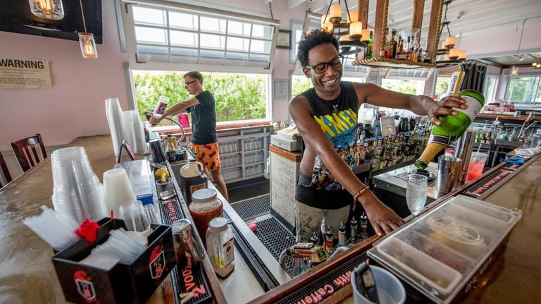 Bartenders mix drinks at the Sand Castle restaurant in Cherry...