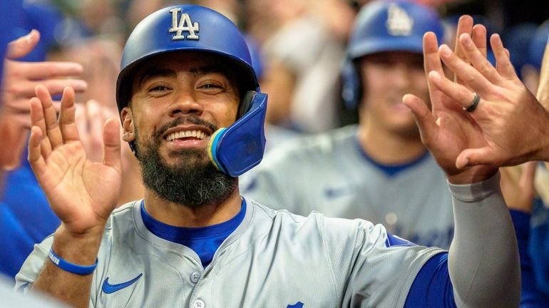 Los Angeles Dodgers' Teoscar Hernández celebrates in the dugout after...