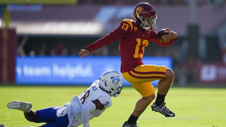 Southern California quarterback Caleb Williams (13) evades a tackle attempt...