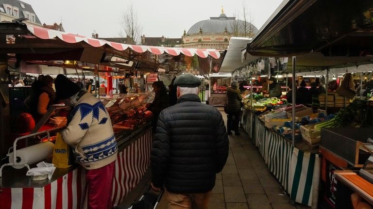 People shop at an open air market in Fontainebleau, south...