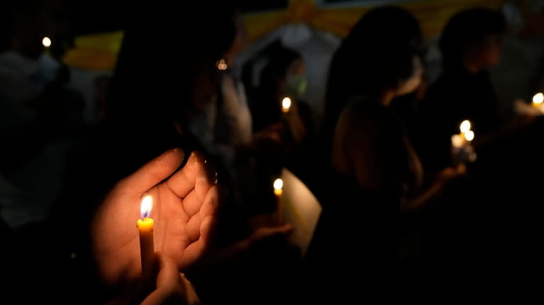 Thai activists hold candles during a vigil for Netiporn Sanesangkhom,...