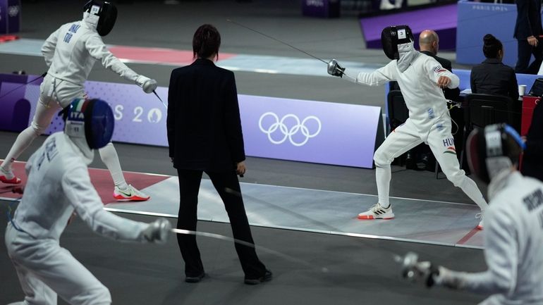 A referee observes as players compete in the men's individual...