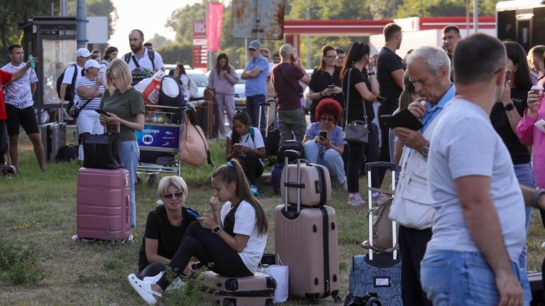 Travelers stand outside the Chisinau airport in Moldova Friday, June...