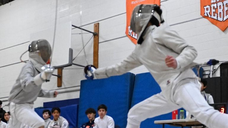 Brandon Lim of Syosset (right) lunges toward his Great Neck...