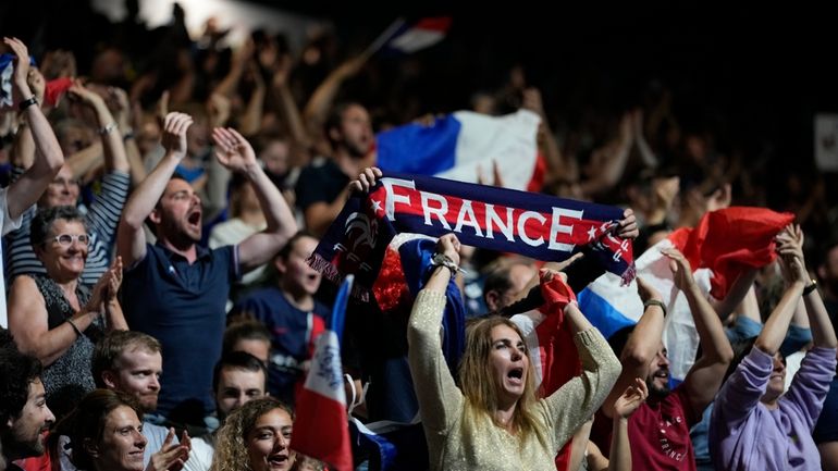 French supporters cheer for their team against Denmark at a...