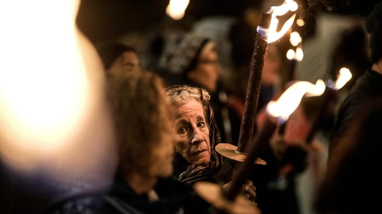 People hold torches as they demand the immediate release of...