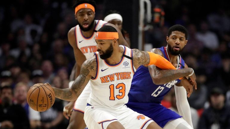 New York Knicks' Marcus Morris Sr., front left, is defended...