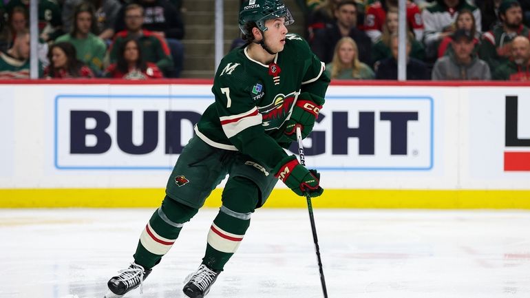 Minnesota Wild defenseman Brock Faber skates with the puck during...