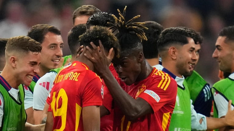 Spain's Lamine Yamal celebrates with his teammate after scoring his...