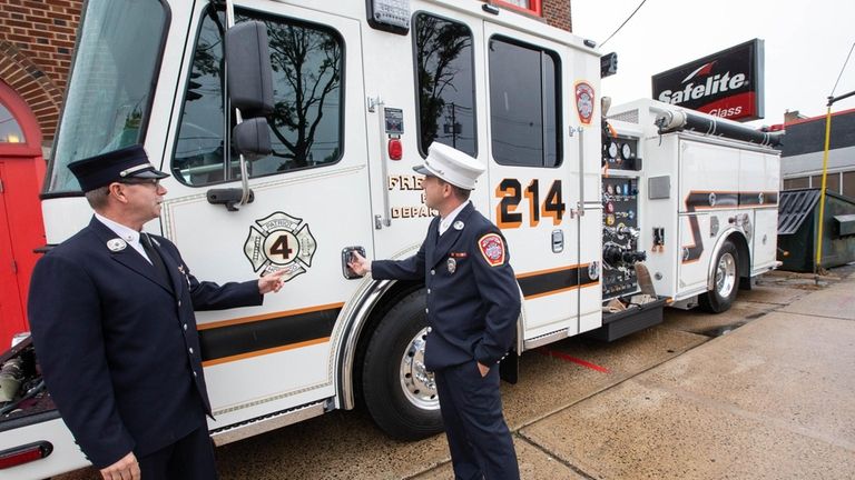 Firefighters Tom Laffin, left, and Kevin Madigan look at the new...